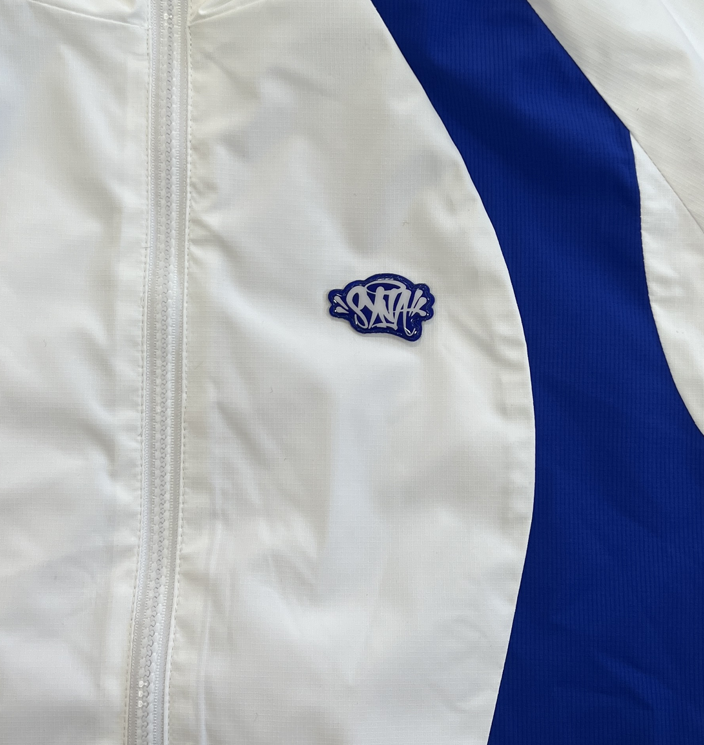 SYNA LOGO VORTEX WOVEN JACKET (WHITE/BLUE)